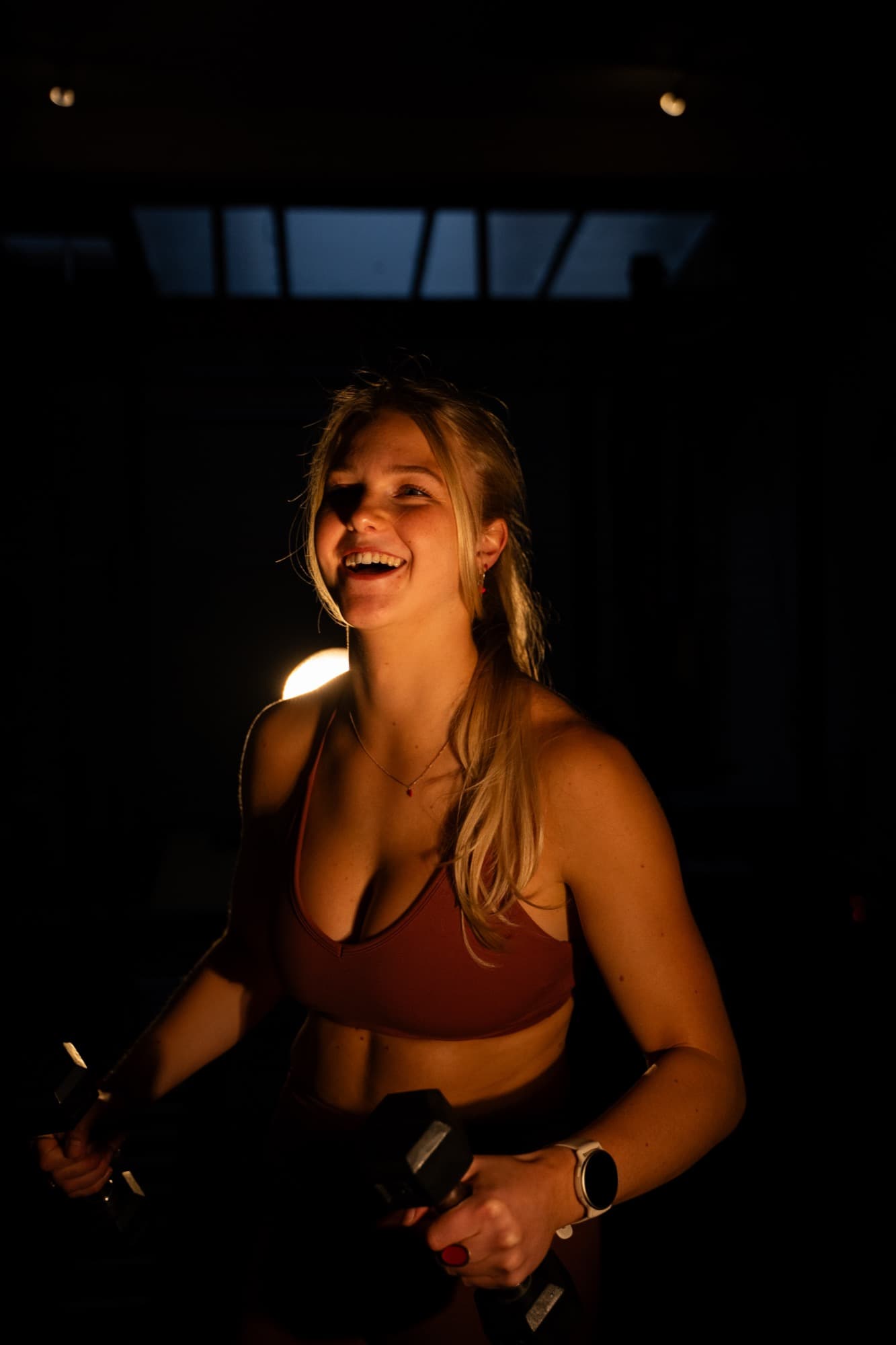 Lachend met dumbbells bij SculptClub privé studio