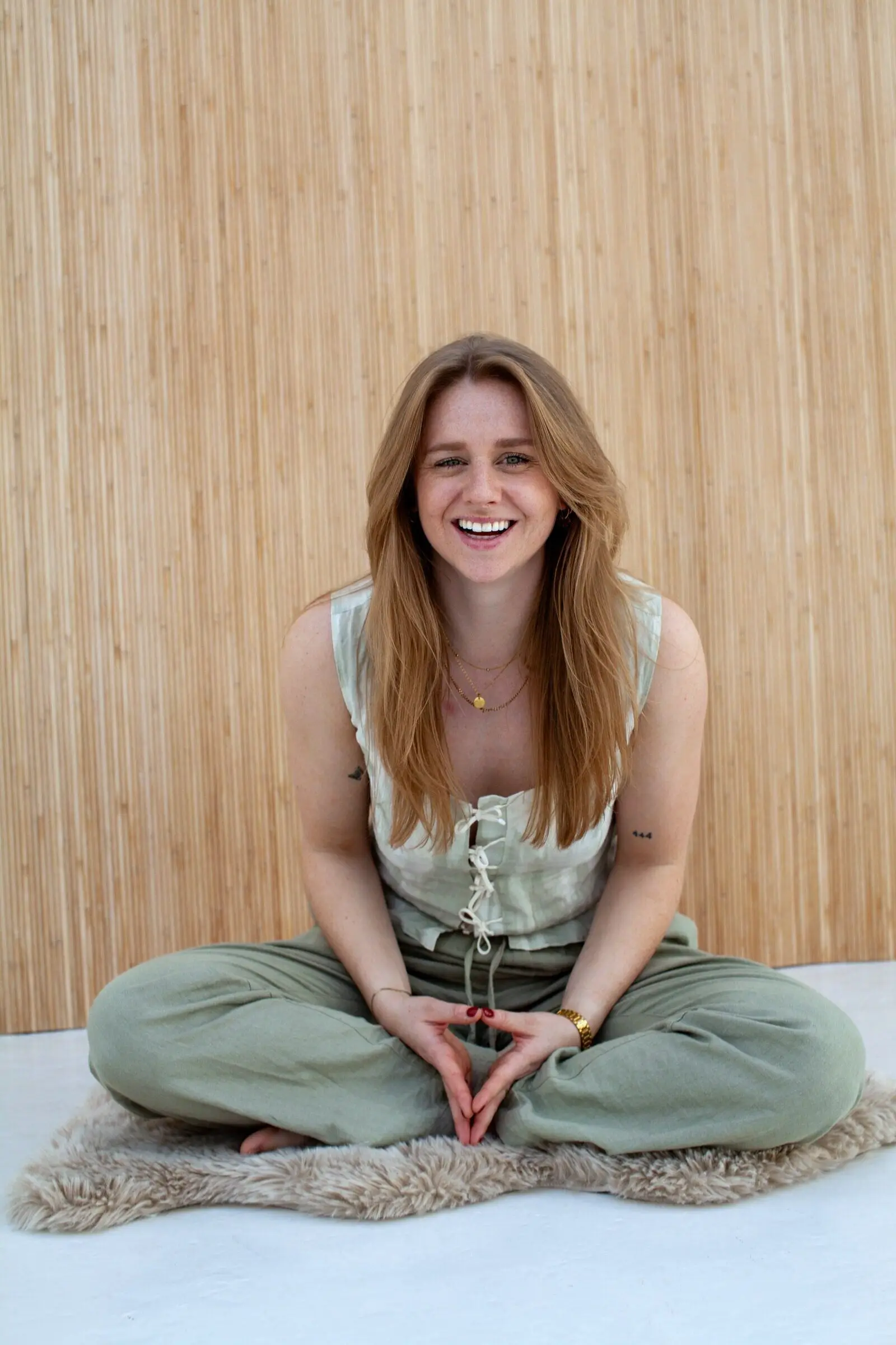 Eva, dietitian and personal trainer, sitting on a rug and smiling